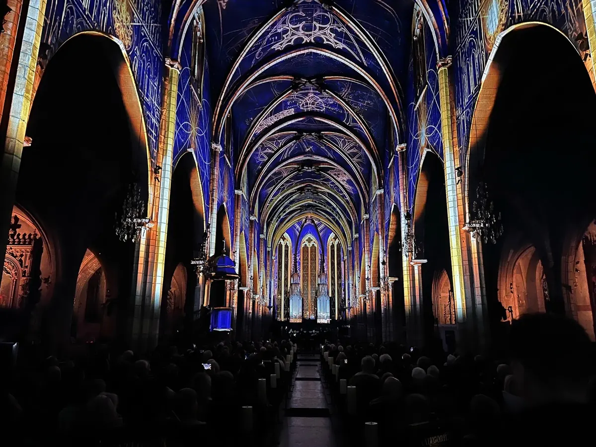 Mise en lumière et vidéo-mapping bleu et or d'une église lors d'un spectacle en Auvergne
