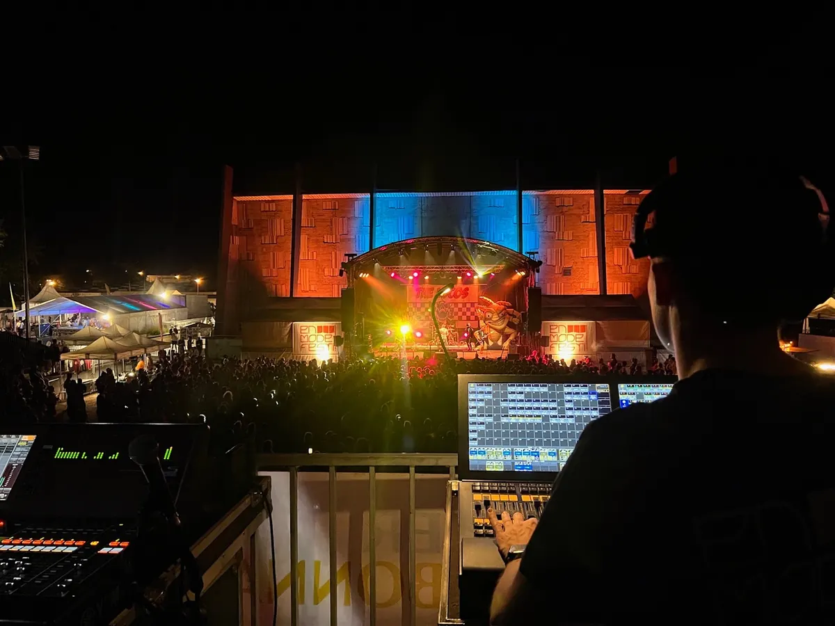 Technicien Scenitech à la régie son et lumière face à la scène d'un festival en Auvergne