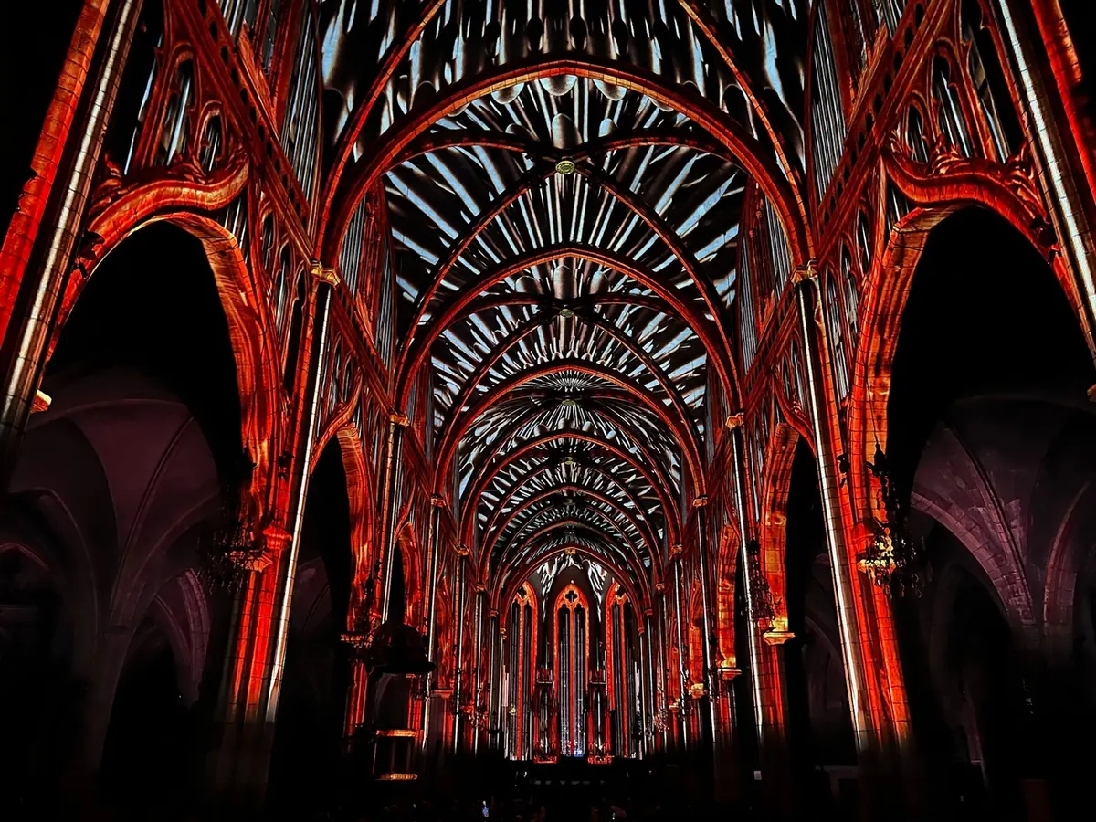 Spectacle de vidéo-mapping en lumière rouge sur les voûtes d'une cathédrale en Auvergne